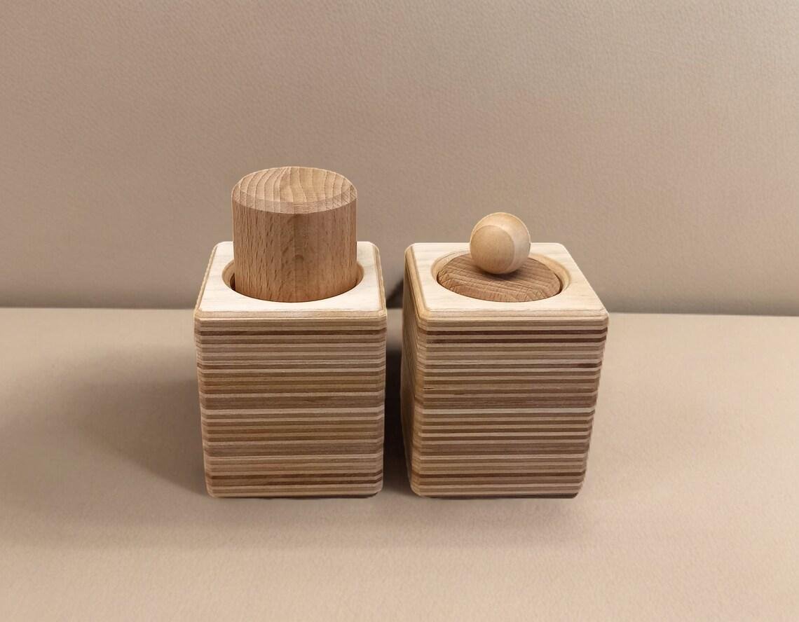 Montessori bloks ar diviem dižskābarža cilindriem plaukstas un knaibveida satvēriena vingrināšanai.