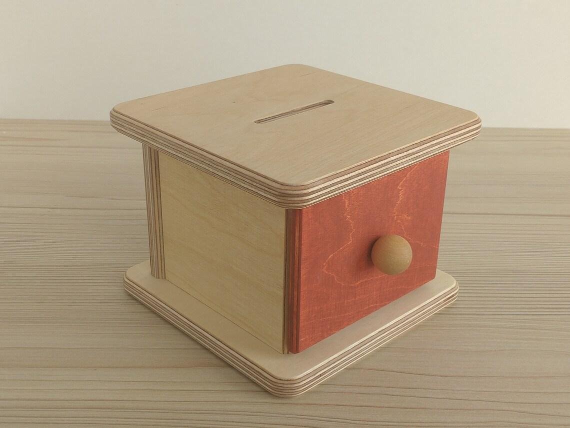 Montessori koka monētu kaste ar izvelkamu atvilktni un trim apaļām bērza monētām.